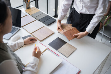 Client and interior designer selecting materials for home decoration in collaborative consultant