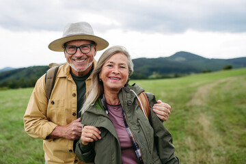 Older couple on group trip in autumn nature.