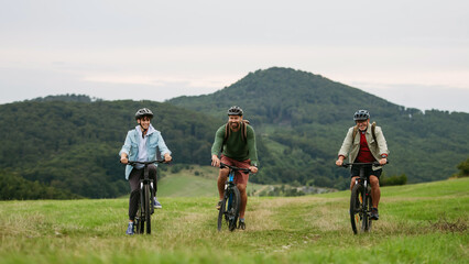 Fototapeta premium Grandfather, father and teen boy on cycling trip in nature.