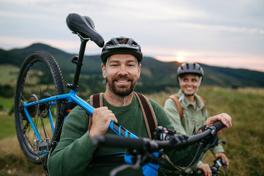 Couple cycling together in nature, smiling and enjoying outdoor adventure. - Powered by Adobe