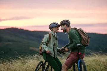 Fototapete Rund Extremsportarten Couple cycling together in nature, smiling and enjoying outdoor adventure.  © Halfpoint