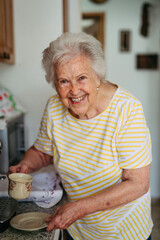 Elderly lady making coffee in coffee maker at morning.