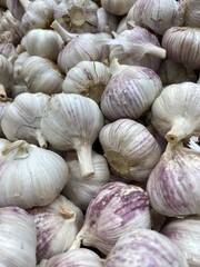 Garlic bulbs closely packed in a pile viewable from above as a textured background