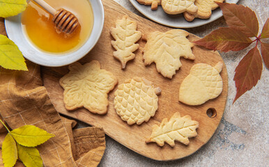 Autumn leaf cookies with honey on wooden board