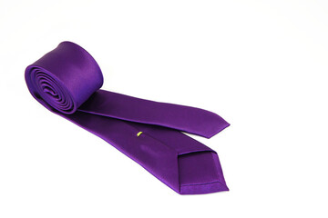 A purple color polyester fabric necktie rolled on white background close-up view 