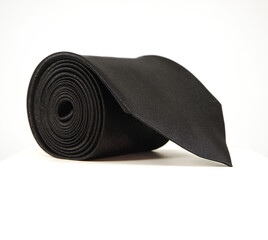 Black tie rolled isolated on white background close-up view 