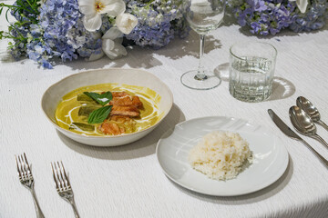 a bowl of Thai style hot green curry soup with grilled chicken slices