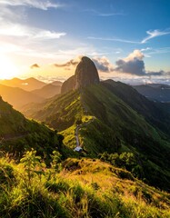 Mountain peak at golden sunset. Lush green hills, winding path