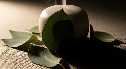 White aroma diffuser emitting steam, surrounded by fresh eucalyptus leaves on a textured linen table in soft, natural light, promoting a sense of calm and relaxation.