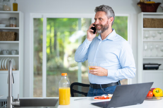 Middle aged Man eat breakfast in the kitchen on a morning. Guy eat vegetables for a healthy meal in his kitchen in morning. Man eat healthy food in kitchen. Morning breakfast in the modern kitchen.