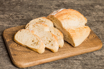 Assortment of freshly sliced baked bread with napkin on rustic table top view. Healthy unleavened bread. French bread slice