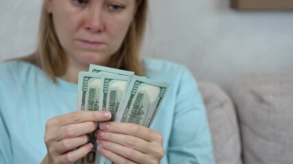 Struggling to manage high utility bills can create stress and anxiety. This clip captures a person's concern while counting cash and worrying about expenses and household budgets.
