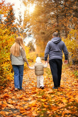 Fototapeta premium A family taking a walk in an autumn park