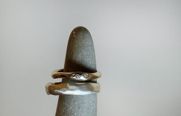 Thin twined silver rings on granite spear, symbolizing ancient union, Celtic handfasting, and...