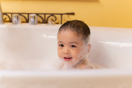Children playing in the bathroom, in the bathtub