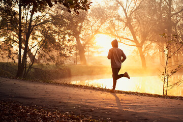 Man running on autumn morning run in park