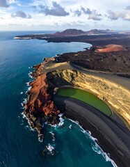 Aerial view of a vibrant coastal landscape showcasing a lagoon and volcanic rock meeting the ocean