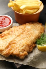 British Traditional Fish and chips served with sauce on table, closeup