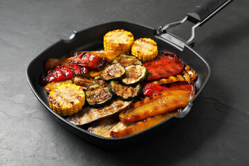 Delicious grilled vegetables in pan on dark textured table, closeup