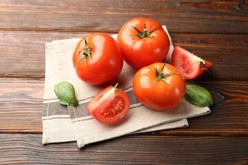 Fresh ripe tomatoes and basil on wooden table, closeup
