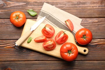 Fresh ripe tomatoes, basil and knife on wooden table, flat lay