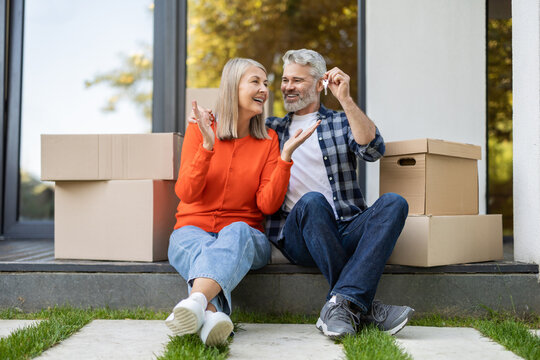 Mature couple celebrating new home ownership smiling with keys - Powered by Adobe