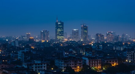 Naklejka premium Nighttime cityscape with illuminated skyscrapers and urban glow under a dark blue sky.