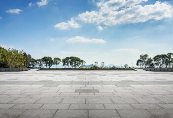 Expansive Outdoor Plaza with Lush Trees and Clear Blue Sky