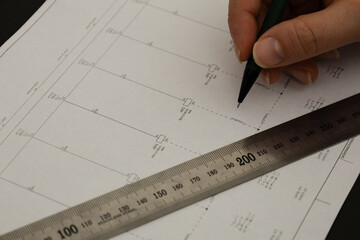 Hand drawing on technical blueprint with pen and ruler