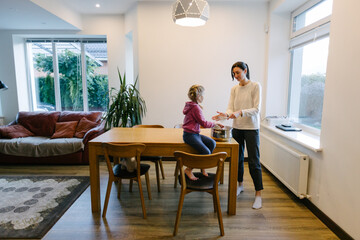 Woman cooking food indoors with a kid