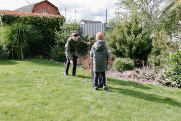 mother and a boy kid cleaning the backyard