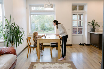 Woman and a kid drawing indoors