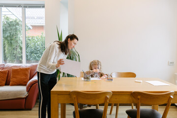 Woman and a kid drawing indoors