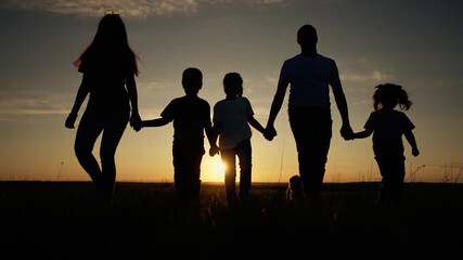 Family walks outdoors at sunset, cherishing moments of togetherness. Sunset walk brings parents and children closer, highlighting joy and love. Outdoors family moments capture happiness and unity