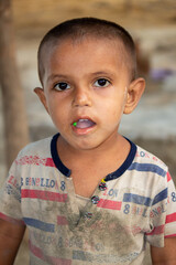 Cute Pakistani boy wearing striped shirt and he is looking at camera