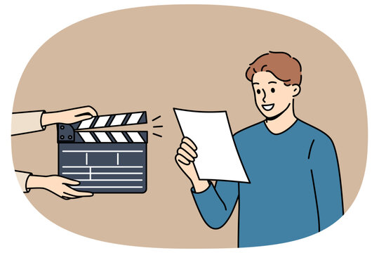 Man actor participates in casting, reading text from piece of paper, standing near clapperboard. Guy participates in casting and starred in popular tv series or movies to become famous star.