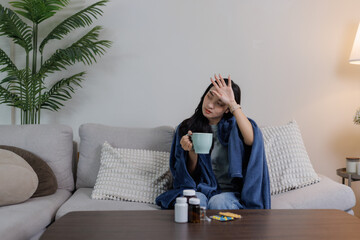 Obraz premium Woman feeling unwell having fever on a sofa