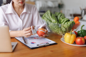Woman measuring apple for healthy diet planning