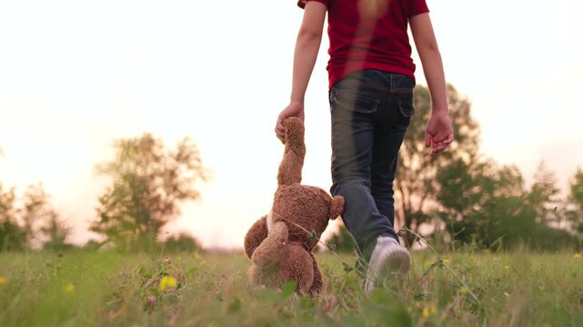 Little boy and his teddy, Kid exploring with stuffed animal, Holding onto childhood, Walking hand in hand with bear, Outdoor playtime nostalgia, Comfort toy outdoors, Childhood companion, Embracing