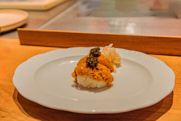 Gourmet sushi dish featuring sea urchin and caviar on elegant plate
