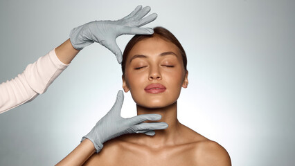 Calm woman with closed eyes and doctor hands showing trust harmony and professional care. Concept...