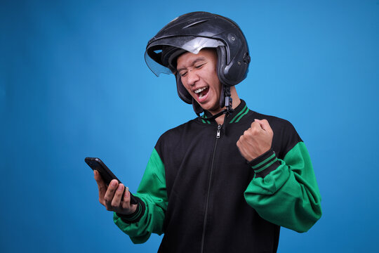 Happy Asian Man Perhaps Online Driver, Excited About Order or Achievement on His Mobile Device