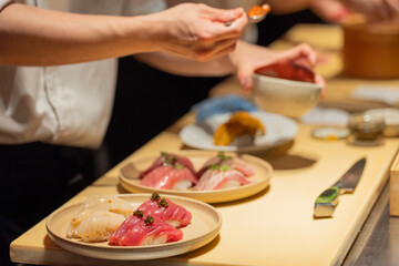 Sushi chef preparing fresh sushi dishes with vibrant ingredients on display