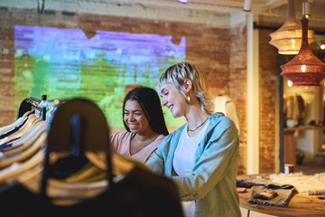 Two young women smiling while shopping together in boutique