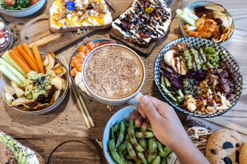 Hand holding coffee cup during healthy brunch meal
