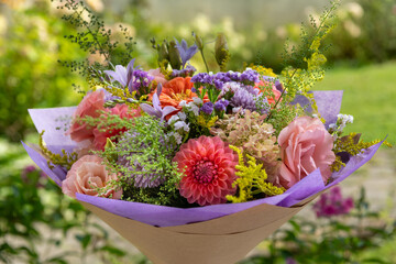 Summer bouquet. Beautiful purple, blush and orange fresh flower arrangement. Birthday or weddding bouquet made of summer flowers.