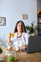 Engaged in her freelance work, a woman with Waardenburg syndrome sips tea at home