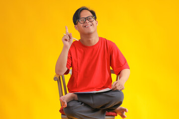 Student with Bright Idea Holds Pen and Notebook, Celebrating Learning on Vibrant Yellow Studio