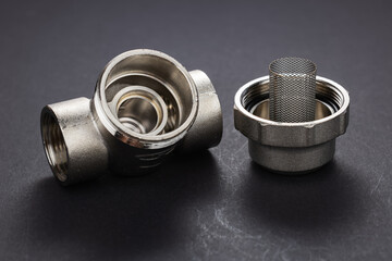 Coarse water filter for plumbing works isolated on dark background