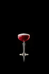 Red foamy cocktail in elegant glass on black reflective surface. Concept of sophistication and calm luxury for alcohol branding, lifestyle visuals, and premium advertising.